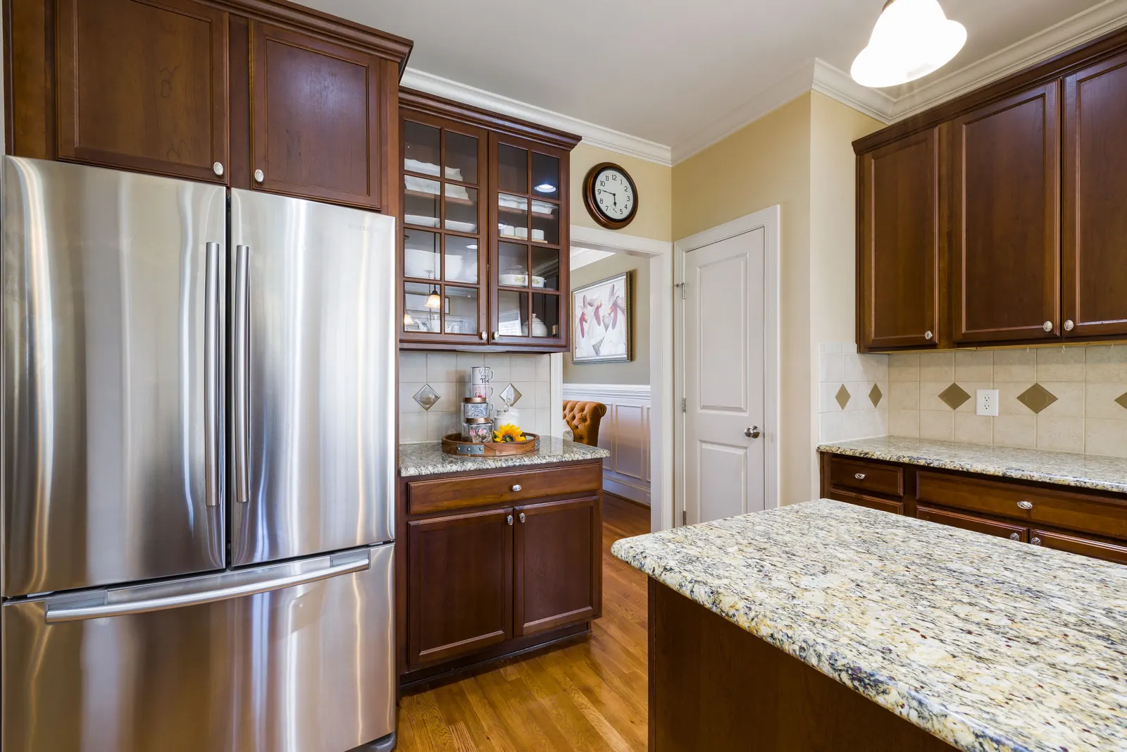 Dark cherry cabinets with a glazed display cabinet and granite island