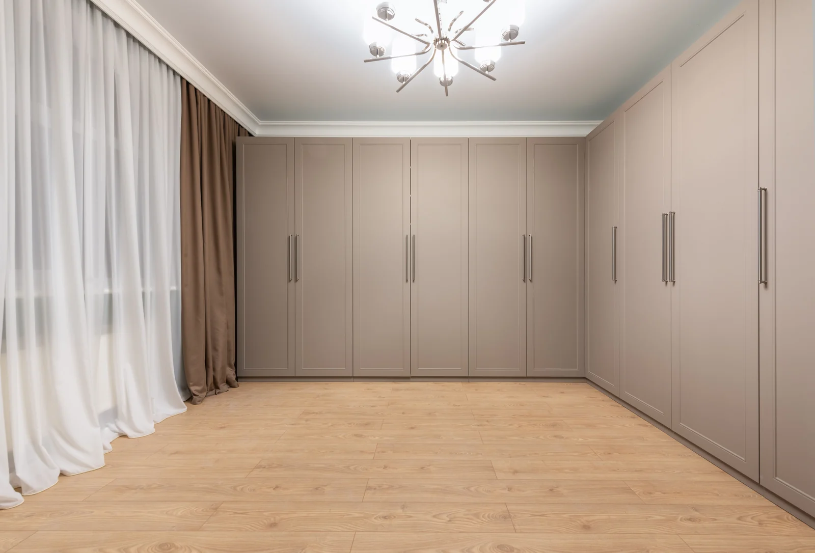 A full wall of greige shaker fitted wardrobes