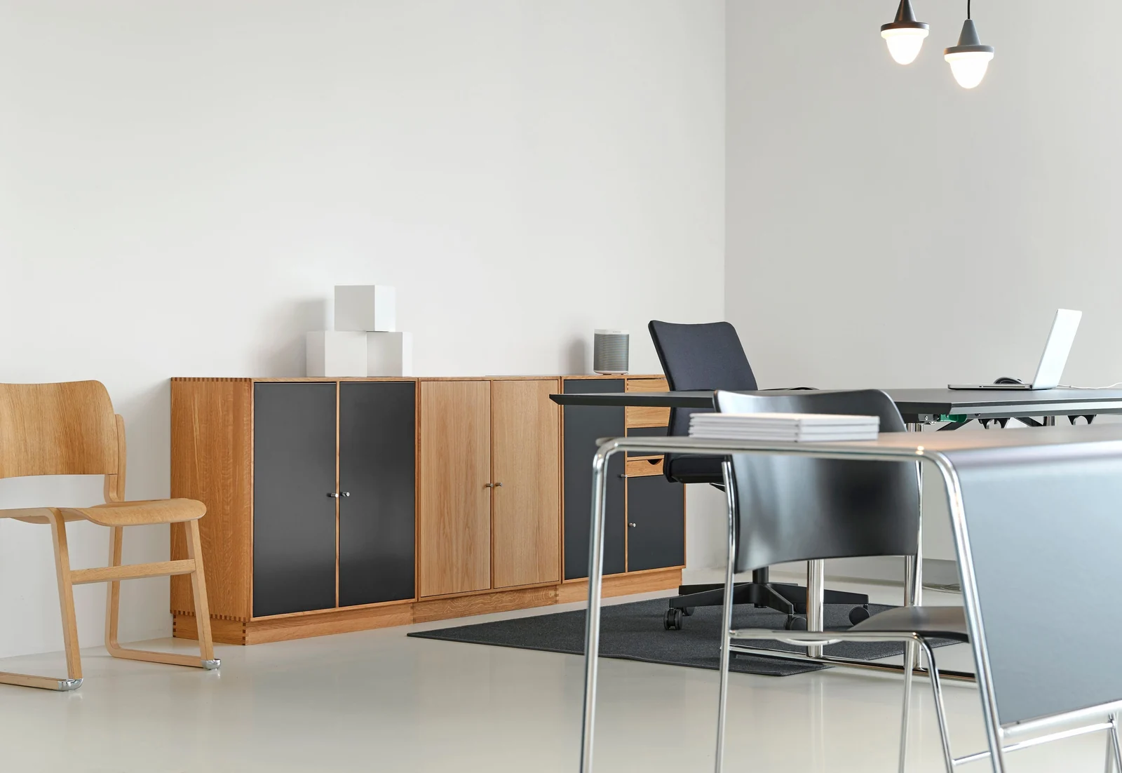 An oak and black office credenza beside a meeting table