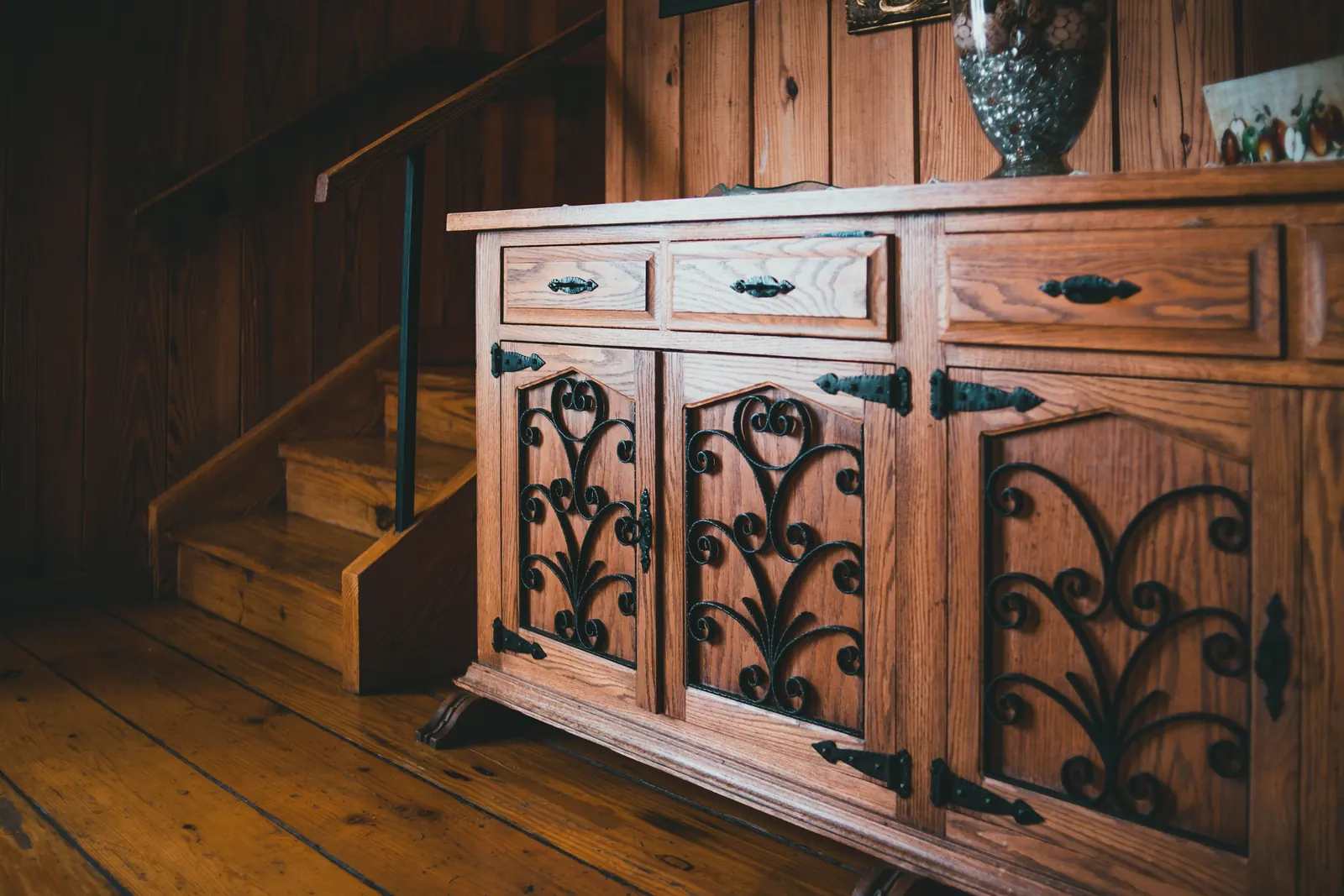 An oak sideboard with wrought-iron scrollwork door panels