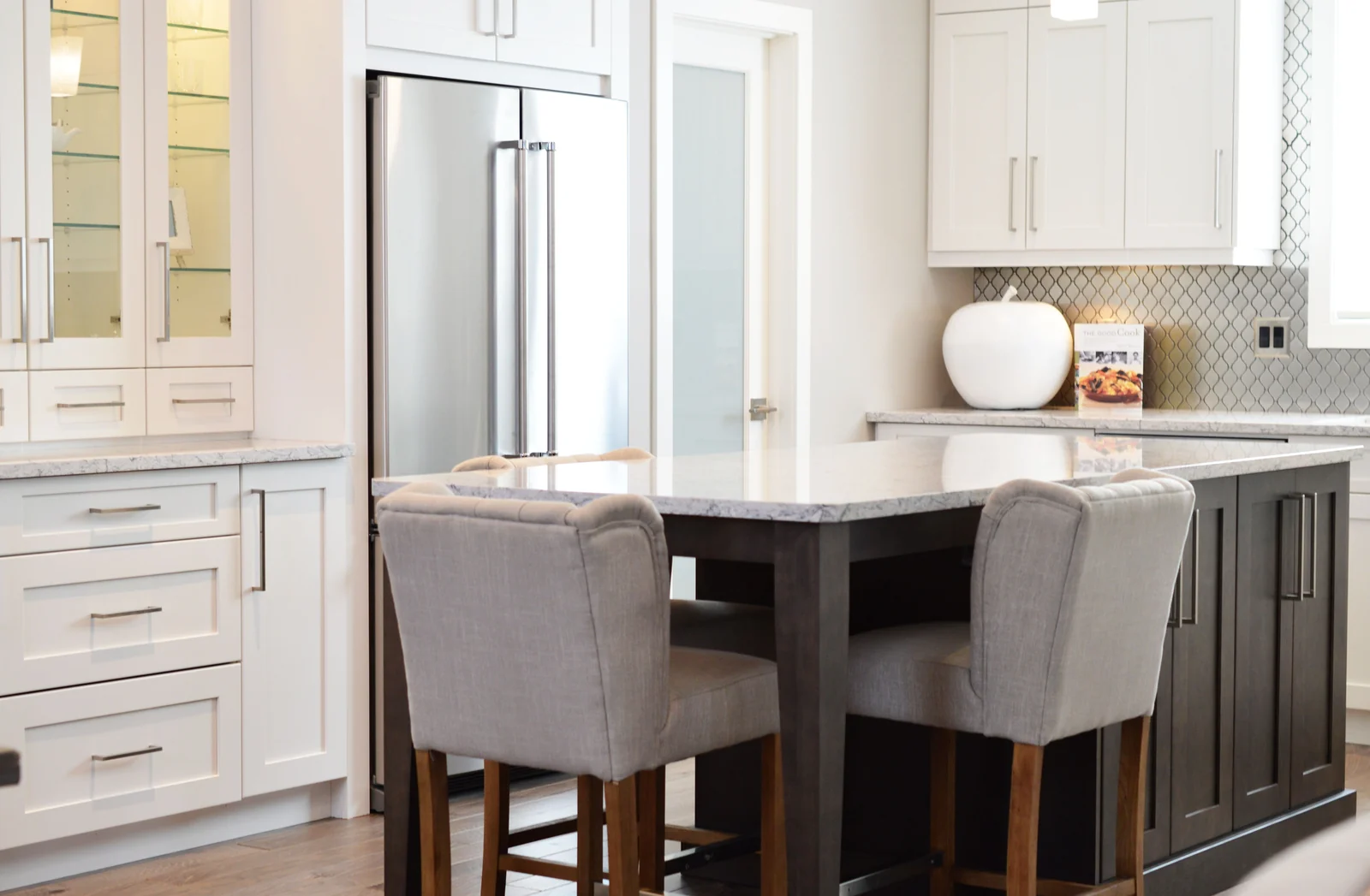 White shaker cabinets with a dark island and built-in seating