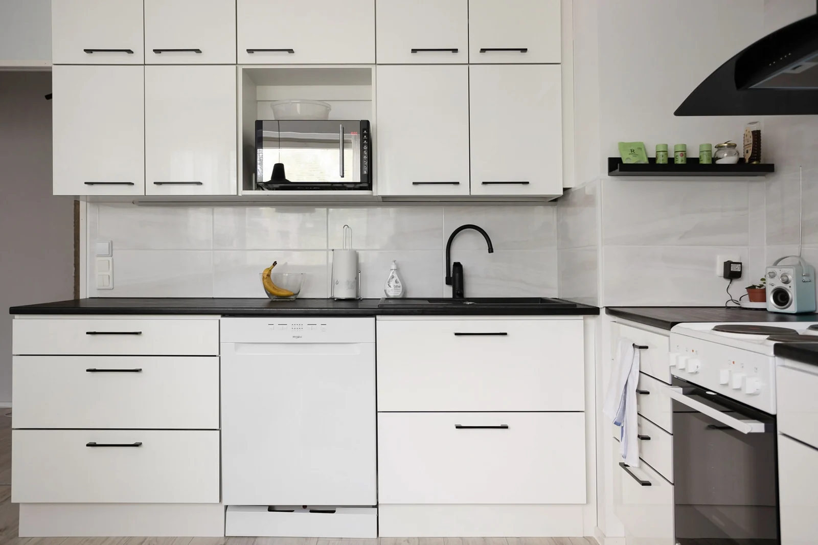 White slab doors with black bar handles and a dark worktop